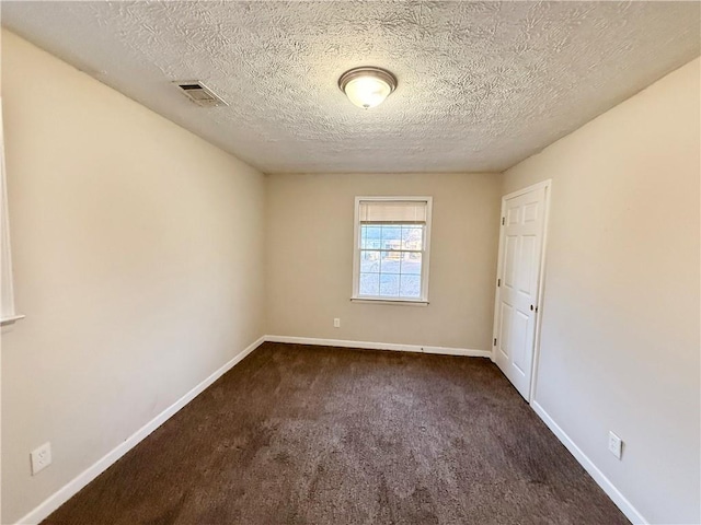 carpeted spare room featuring a textured ceiling