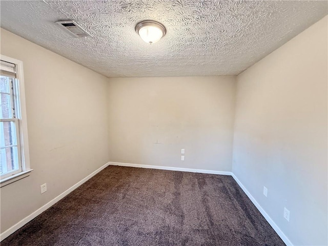 carpeted spare room with a textured ceiling