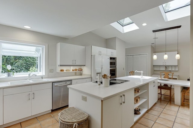 3219 Parkridge Cres, Chamblee, GA 30341 - kitchen with appliances with stainless steel finishes, a skylight, light tile patterned floors, light countertops, and a center island with sink