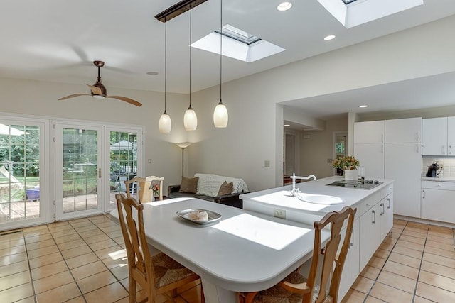 3219 Parkridge Cres, Chamblee, GA 30341 - kitchen featuring a skylight, light tile patterned flooring, a center island with sink, hanging light fixtures, and white cabinets