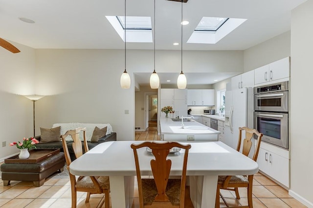3219 Parkridge Cres, Chamblee, GA 30341 - kitchen with stainless steel double oven, a skylight, white refrigerator with ice dispenser, a center island with sink, and light countertops