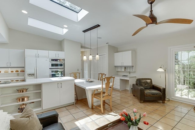 3219 Parkridge Cres, Chamblee, GA 30341 - kitchen featuring white fridge with ice dispenser, stainless steel double oven, light tile patterned floors, a skylight, and pendant lighting