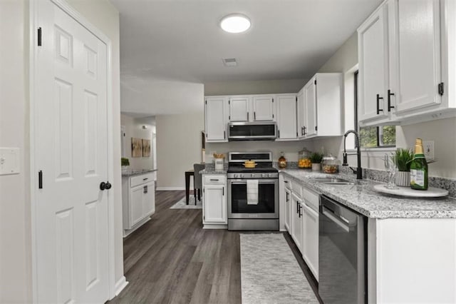 4912 Bayside Ct, Stone Mountain, GA 30088 - kitchen with appliances with stainless steel finishes, white cabinetry, dark wood finished floors, and light stone countertops