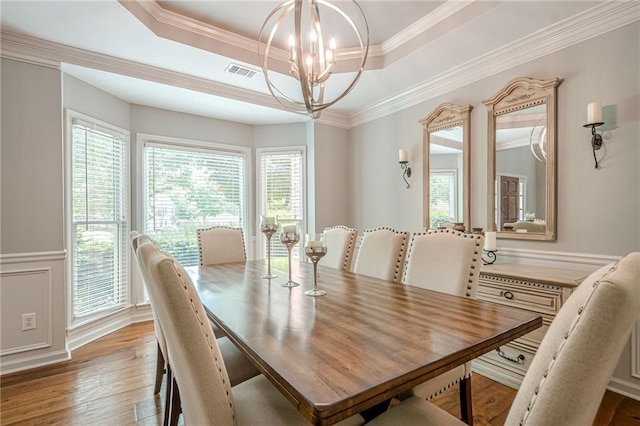 10865 Glenhurst Pass, Duluth, GA 30097 - dining space with a chandelier, a raised ceiling, plenty of natural light, crown molding, and wainscoting