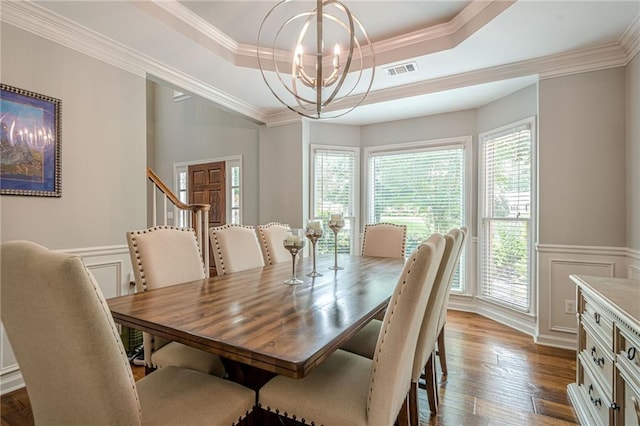 10865 Glenhurst Pass, Duluth, GA 30097 - dining room featuring a raised ceiling, a chandelier, dark wood-type flooring, crown molding, and wainscoting