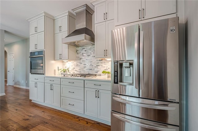 10865 Glenhurst Pass, Duluth, GA 30097 - kitchen with stainless steel appliances, wall chimney exhaust hood, backsplash, dark wood-style floors, and light countertops