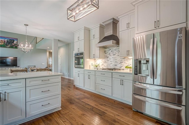 10865 Glenhurst Pass, Duluth, GA 30097 - kitchen featuring appliances with stainless steel finishes, wall chimney exhaust hood, decorative backsplash, a chandelier, and light countertops