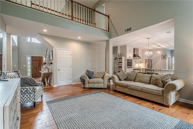 10865 Glenhurst Pass, Duluth, GA 30097 - living room with a high ceiling, light wood finished floors, and a chandelier
