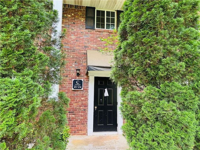 view of exterior entry featuring brick siding