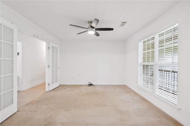 carpeted empty room featuring ceiling fan and french doors