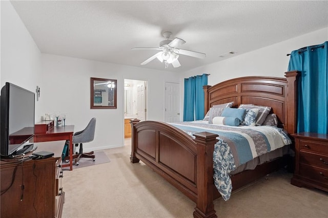 bedroom featuring ensuite bathroom, light carpet, a textured ceiling, and ceiling fan