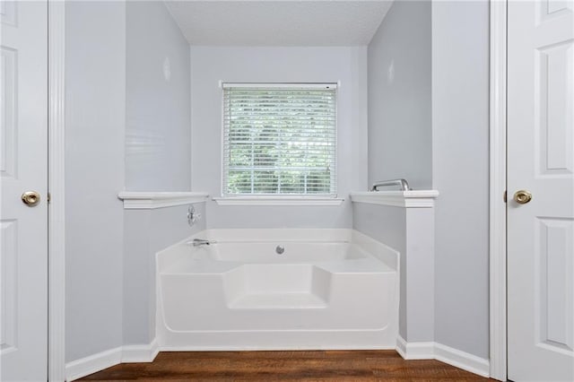 bathroom with a textured ceiling and a bathing tub