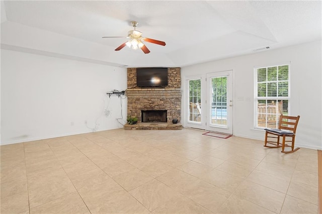 unfurnished living room with a raised ceiling, ceiling fan, light tile patterned floors, and a fireplace