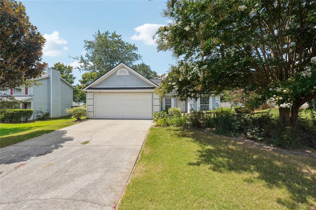 view of front of property with a garage, driveway, and a front yard