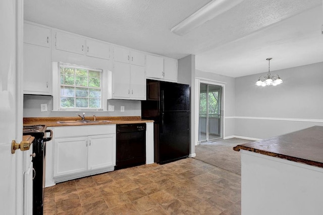 kitchen with an inviting chandelier, white cabinetry, a sink, black appliances, and decorative light fixtures