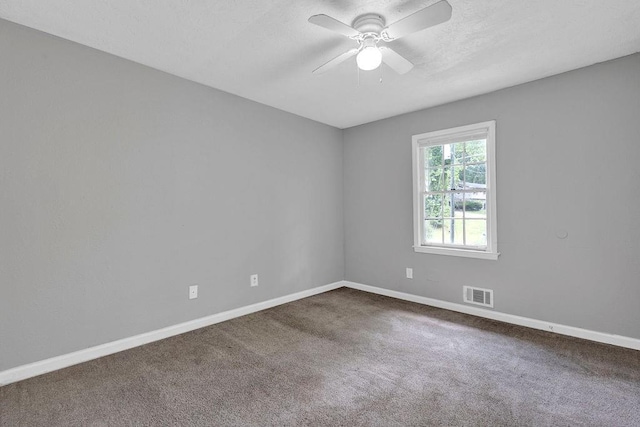 carpeted empty room featuring ceiling fan, visible vents, and baseboards