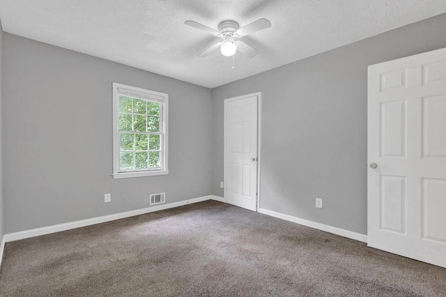 unfurnished bedroom with baseboards, visible vents, ceiling fan, and carpet
