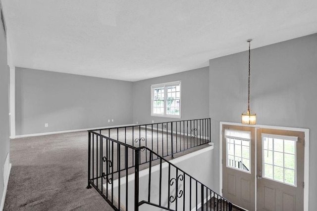staircase with baseboards and carpet flooring