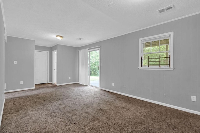 carpeted empty room with crown molding, baseboards, a textured ceiling, and visible vents