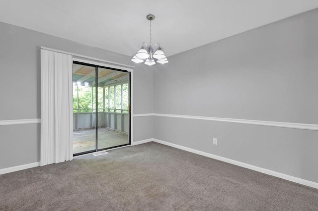 carpeted spare room with baseboards and a chandelier