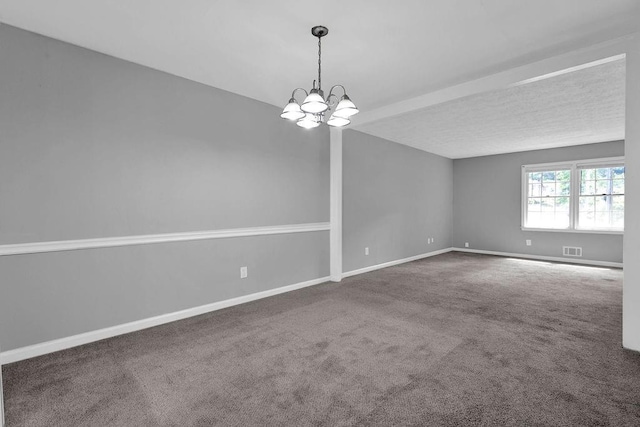 carpeted empty room featuring an inviting chandelier, baseboards, and visible vents
