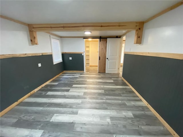 basement featuring wood-type flooring and a barn door