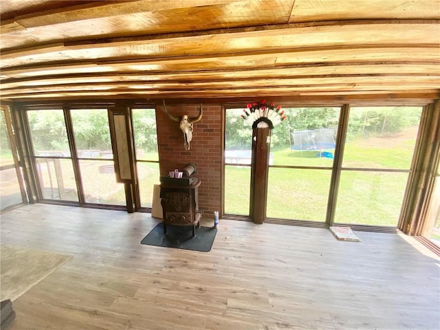 interior space with beam ceiling and a wood stove