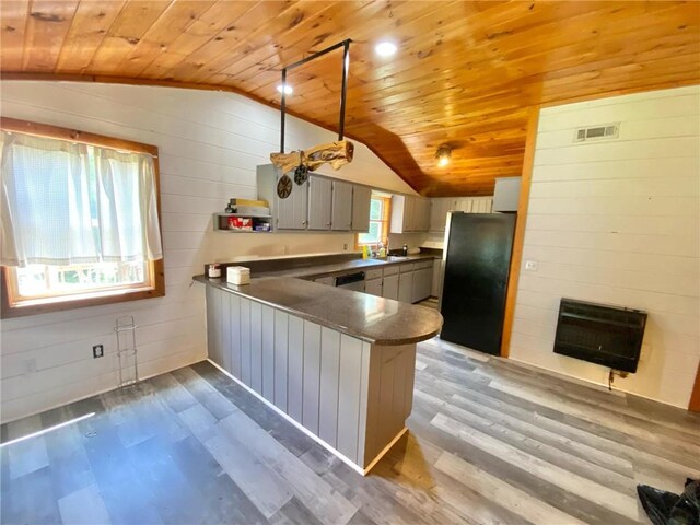 details featuring stainless steel fridge, dark stone countertops, and light hardwood / wood-style flooring