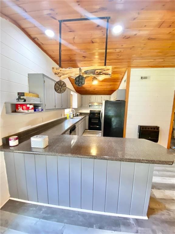 kitchen with kitchen peninsula, black refrigerator, gray cabinets, and wooden ceiling