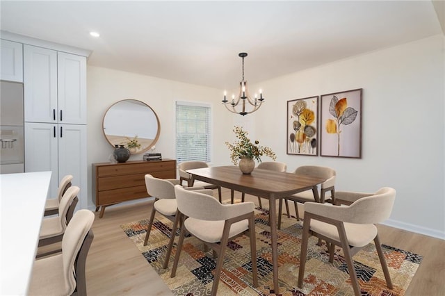 dining area with an inviting chandelier and light wood-type flooring