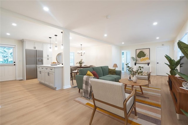 living room with a notable chandelier and light hardwood / wood-style floors