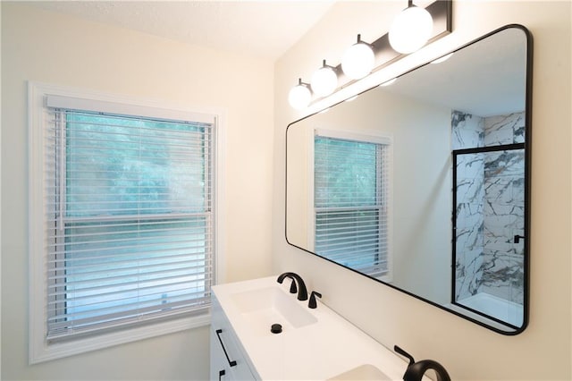 bathroom with a shower with shower door and vanity