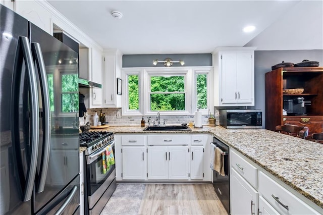21 Basin Ct, Jasper, GA 30143 - kitchen with appliances with stainless steel finishes, tasteful backsplash, white cabinets, light stone countertops, and light wood-type flooring
