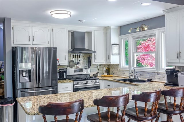21 Basin Ct, Jasper, GA 30143 - kitchen featuring wall chimney exhaust hood, stainless steel appliances, a kitchen bar, backsplash, and a peninsula