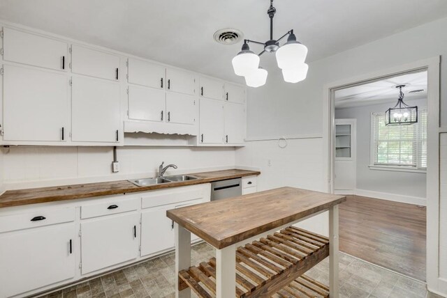 kitchen with pendant lighting, white cabinetry, an inviting chandelier, hardwood / wood-style floors, and wooden counters