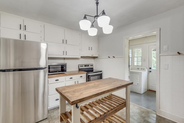 kitchen featuring hanging light fixtures, a chandelier, white cabinetry, washer / clothes dryer, and appliances with stainless steel finishes