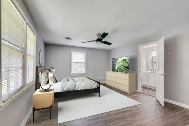 bedroom featuring ceiling fan, connected bathroom, and dark wood-type flooring