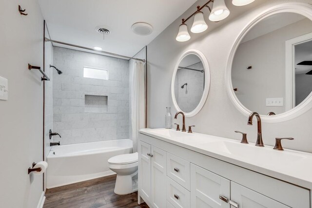 full bathroom featuring vanity, hardwood / wood-style flooring, shower / tub combo, and toilet