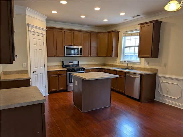 kitchen featuring visible vents, appliances with stainless steel finishes, crown molding, and a sink