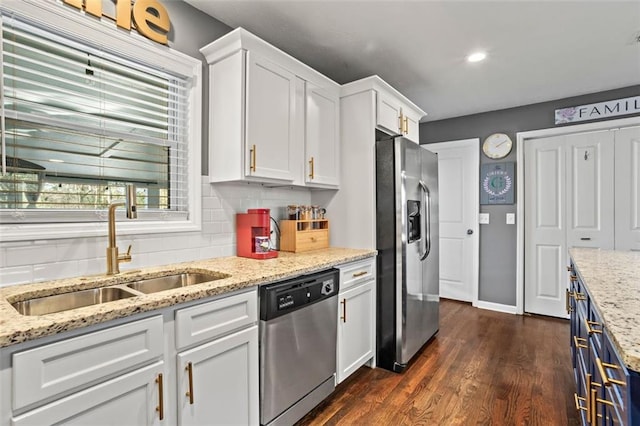 kitchen with tasteful backsplash, dark wood-style floors, white cabinets, stainless steel appliances, and a sink