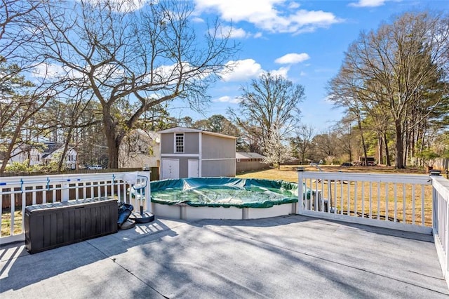 view of patio featuring a covered pool and an outbuilding