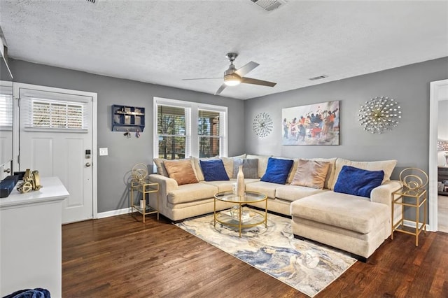 living area with a ceiling fan, baseboards, wood finished floors, visible vents, and a textured ceiling