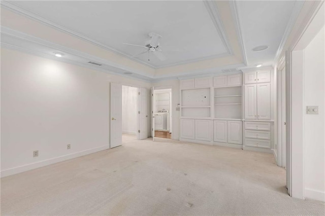 unfurnished bedroom featuring ornamental molding, light colored carpet, ceiling fan, and a raised ceiling