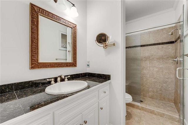 bathroom featuring toilet, vanity, ornamental molding, and a shower with shower door