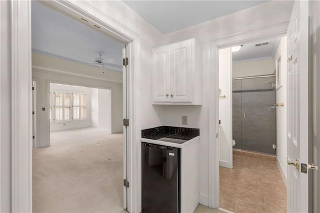 kitchen featuring black dishwasher, light carpet, ceiling fan, crown molding, and white cabinetry