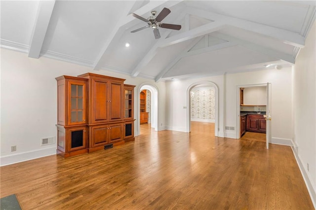 unfurnished living room with hardwood / wood-style flooring, ceiling fan, and vaulted ceiling with beams