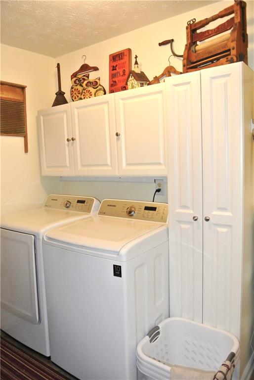 3824 Smith Creek Ct, Buford, GA 30519 - washroom featuring cabinet space, independent washer and dryer, and a textured ceiling
