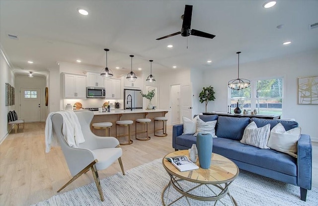 living area featuring recessed lighting, a healthy amount of sunlight, and ceiling fan with notable chandelier