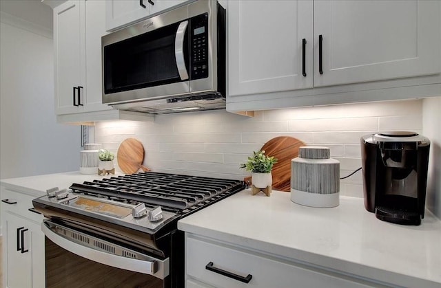 kitchen featuring light countertops, appliances with stainless steel finishes, and tasteful backsplash
