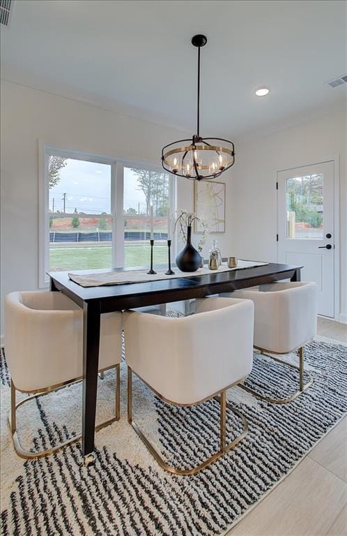 dining area featuring visible vents, light wood-style flooring, and plenty of natural light